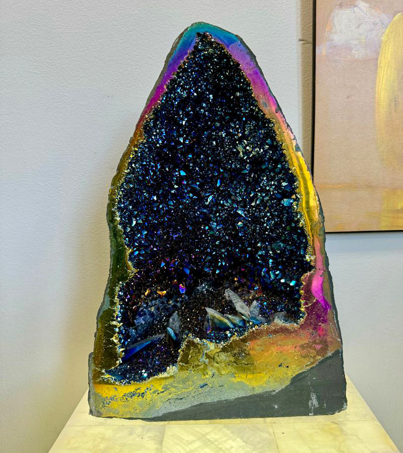 Iridescent titanium aura cathedral geode with vibrant shades of blue, purple, gold, and pink, emitting powerful, high-vibrational energy.