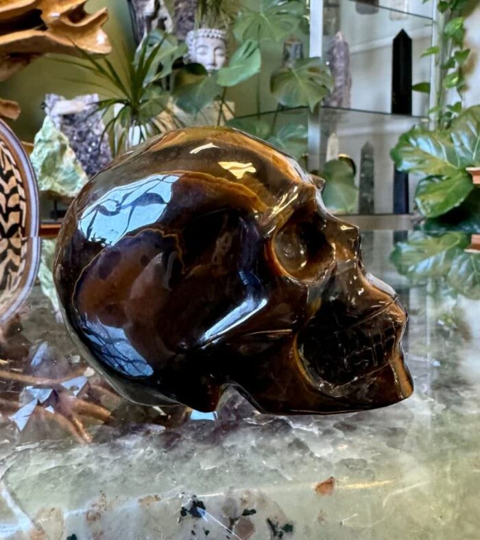 This striking Tiger Eye Crystal Skull is renowned for its powerful protective properties, promoting courage, balance, and mental clarity.