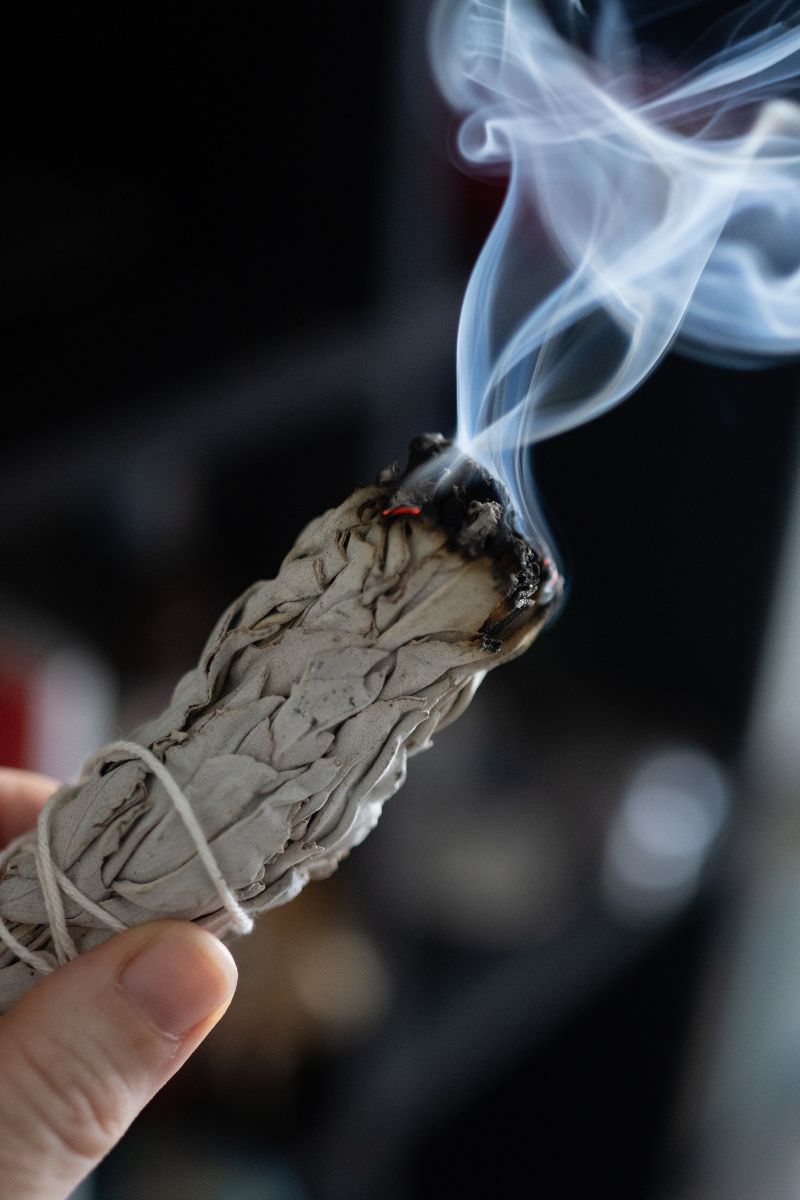 Smoke cleansing ritual with sage bundle for energy purification