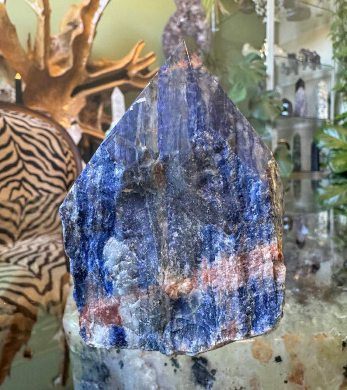 The raw base of the Sodalite remains in its natural, unpolished state, grounding the energy of the crystal and providing a strong foundation of stability